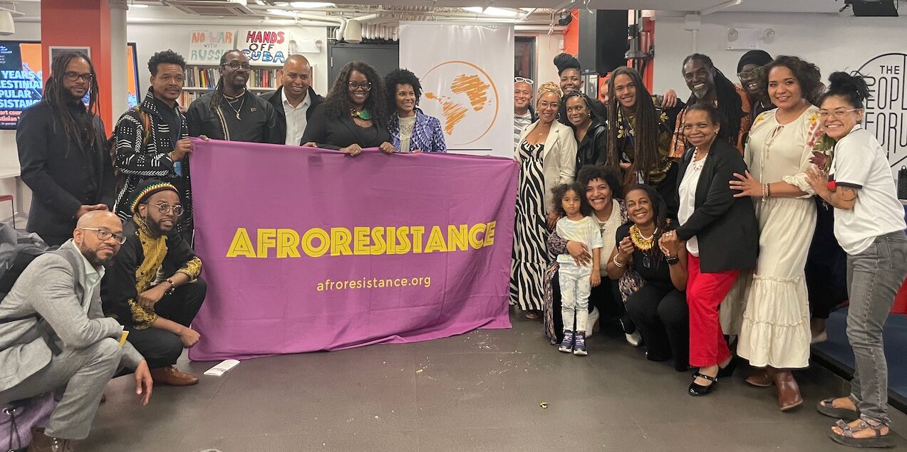 A group of people standing in front of a banner that says "AfroRestistance."
